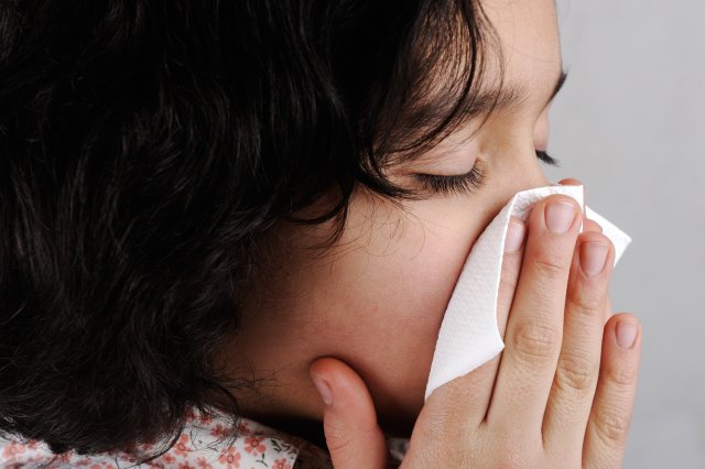 little girl blows her nose