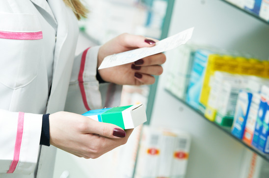 Pharmacist hands with drug and prescription