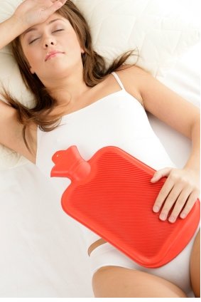 young woman with water pack on stomach